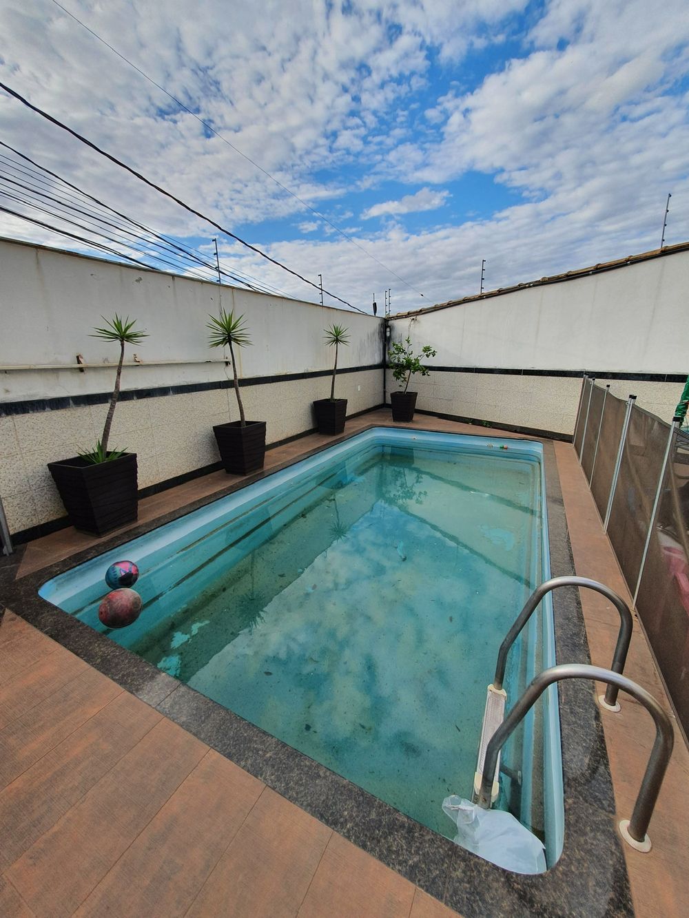 Piscina antes da reforma, com água verde e fibra manchada